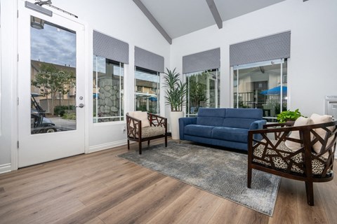 a living room with a blue couch and chairs and sliding glass doors